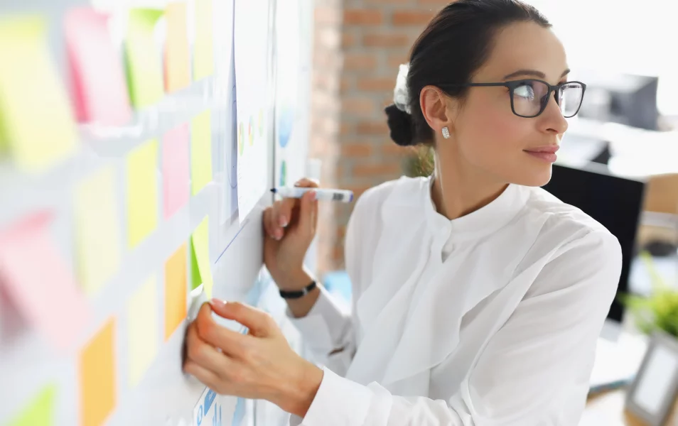 IT software testerka píše lístok na tabuľu agilného vývoja softvéru