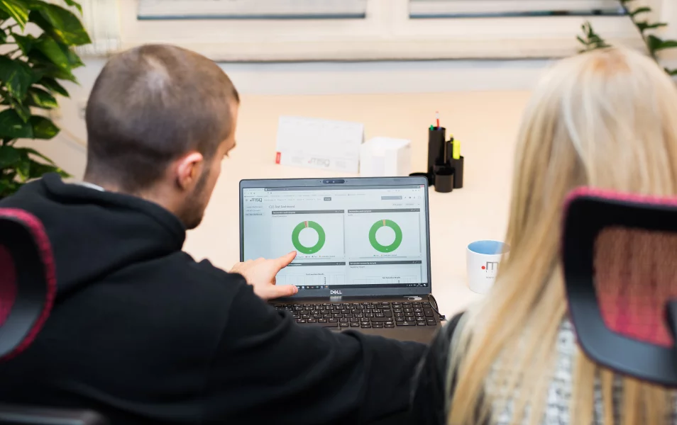 IT software tester ukazuje na monitore grafy a princípy testovania kolegyni