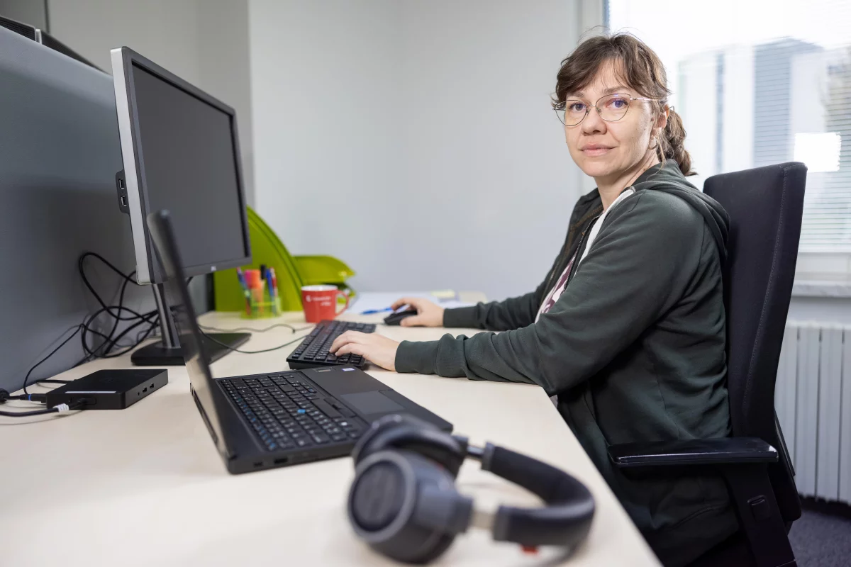 IT business consultantka pózuje za stolom s rukami na klávesnici