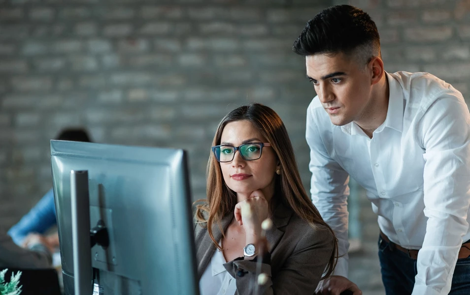 It testetri mladý muž a žena pozerajú do monitora