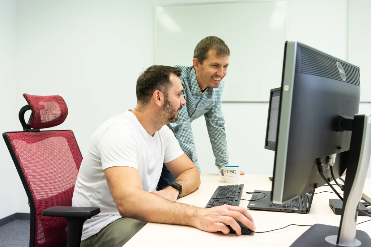 it testeri automatizácie sa radia za stolom pri monitoroch