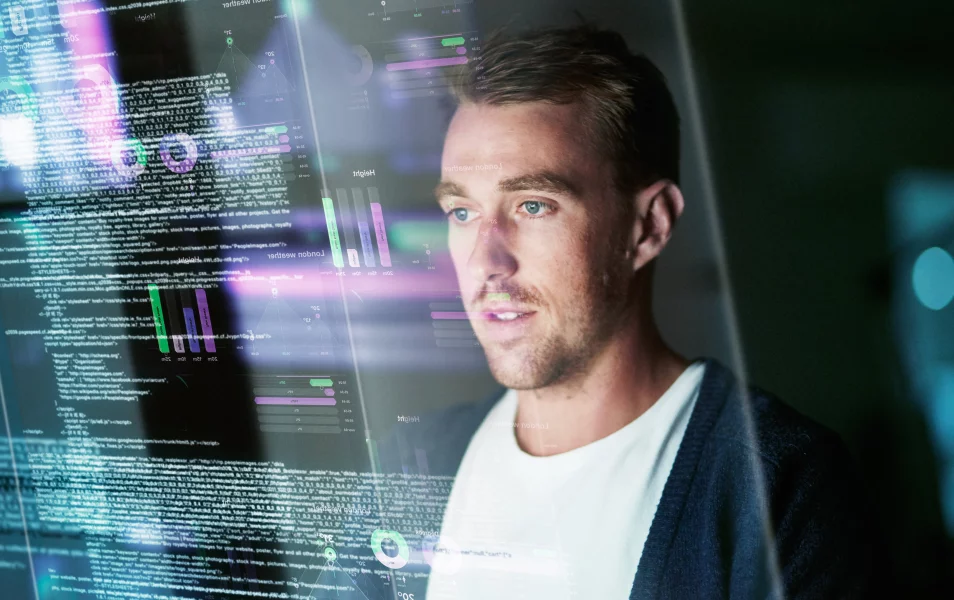 IT tester muž pozerá do kódu na futuristickej priehľadnej obrazovke